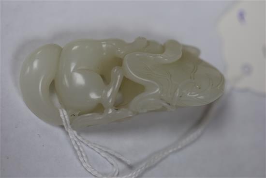 A Chinese white jade carving of a squirrel, grapes and lotus leaf, 18th/19th century, L. 6.4cm, wood stand